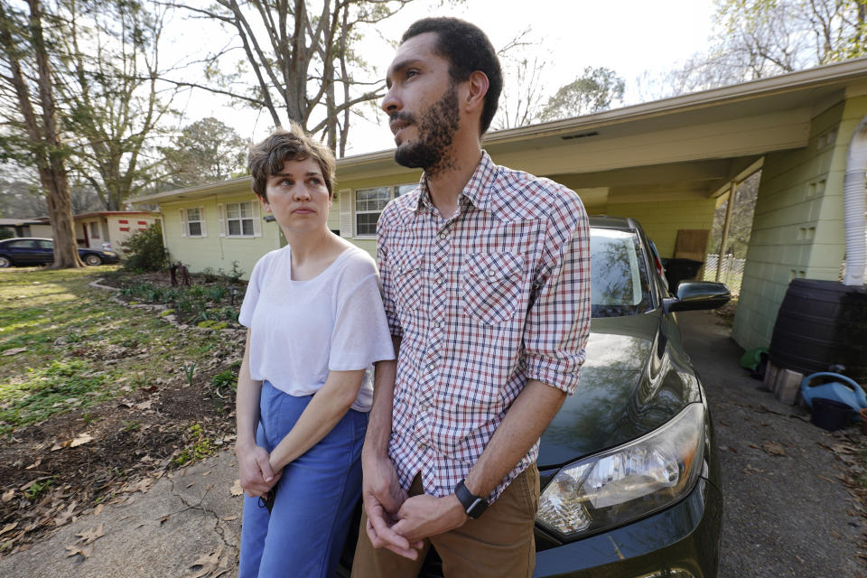 Lauren Rhoades, 32, left, listens as her husband LaQuenza Morgan, 33, speaks about being checked at a roadblock a short distance from their home in north Jackson, Miss., Thursday, Feb. 24, 2022. The two are among several plaintiffs in a lawsuit claiming the Jackson police department is violating people's constitutional rights by using roadblocks to check for driver's licenses and car insurance in majority-Black and low-income neighborhoods. (AP Photo/Rogelio V. Solis)