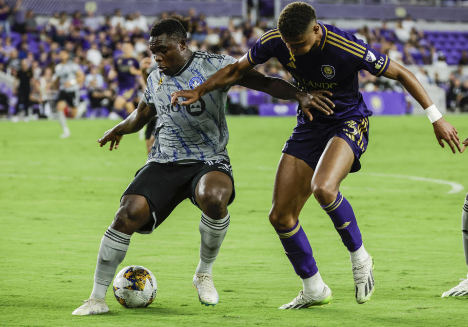 CF Montreal forward Sunusi Ibrahim, left, and Orlando City defender Rafael Santos, right, fight for ball during the second half of an MLS soccer match, Saturday, Sept. 30, 2023, in Orlando, Fla. (AP Photo/Kevin Kolczynski)