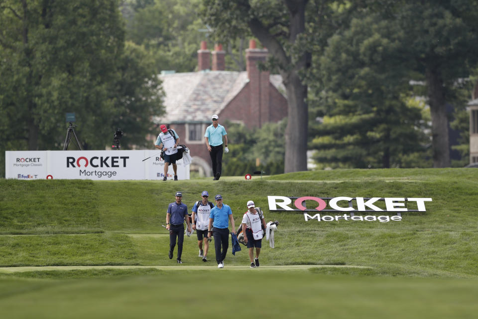 Matt Wallace, front, Sam Ryder, center, and John Senden walk on the ninth fairway during the first round of the Rocket Mortgage Classic golf tournament, Thursday, July 2, 2020, at the Detroit Golf Club in Detroit. (AP Photo/Carlos Osorio)