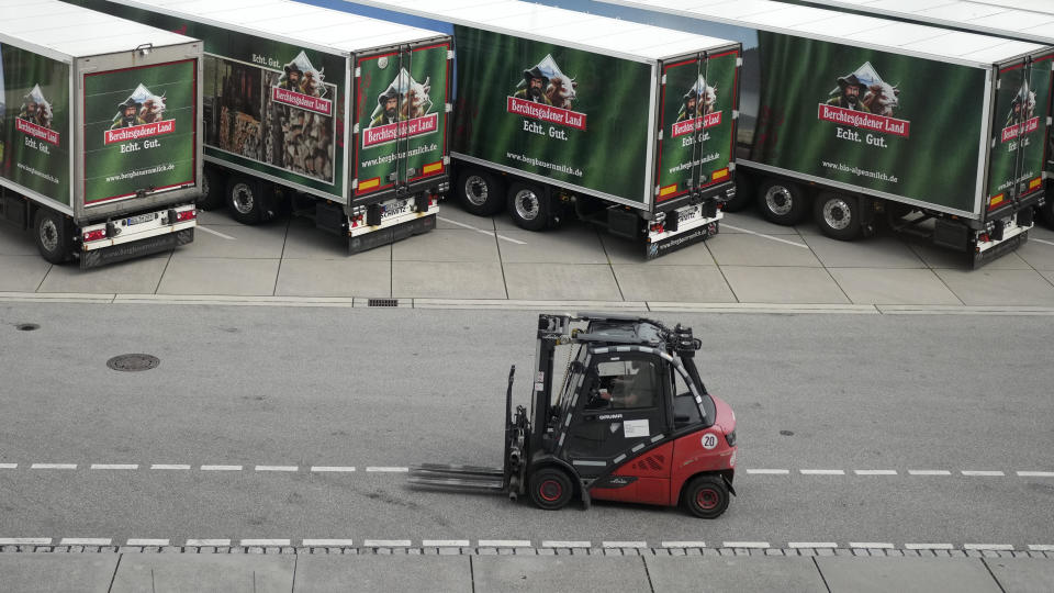 A forklift passes trucks of the Berchtesgadener Land dairy cooperative at the main entrance in Piding near Munich, Germany, Friday, July 15, 2022. The Molkerei Berchtesgadener Land has stockpiled 200,000 liters of fuel oil so it can continue to produce electricity and steam if natural gas supplies to its turbine generator are cut off. (AP Photo/Matthias Schrader)