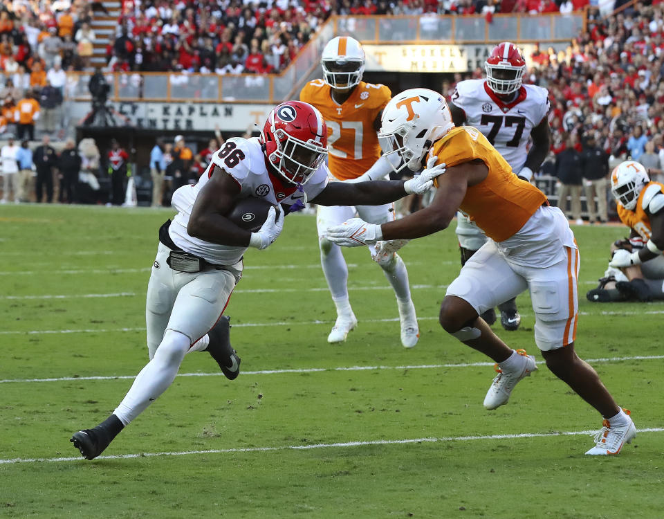 Georgia wide receiver Dillon Bell breaks away from Tennessee defender Gabe Jeudy-Lally for a touchdown during the second quarter of an NCAA college football game, Saturday, Nov. 18, 2023, in Knoxville, Tenn. (Curtis Compton/Atlanta Journal-Constitution via AP)