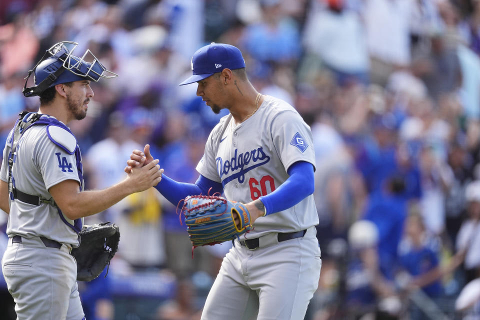 Los Angeles Dodgers catcher Austin Barnes, left, congratulates relief pitcher Edgardo Henriquez after defeting the Colorado Rockies in a baseball game Sunday, Sept. 29, 2024, in Denver. (AP Photo/David Zalubowski)