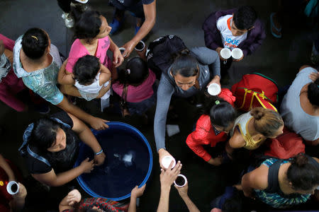 Volunteers hand out coffee to Honduran migrants, part of a caravan trying to reach the U.S., at a church near the border with Mexico, in Tecun Uman, Guatemala October 19, 2018. REUTERS/Ueslei Marcelino