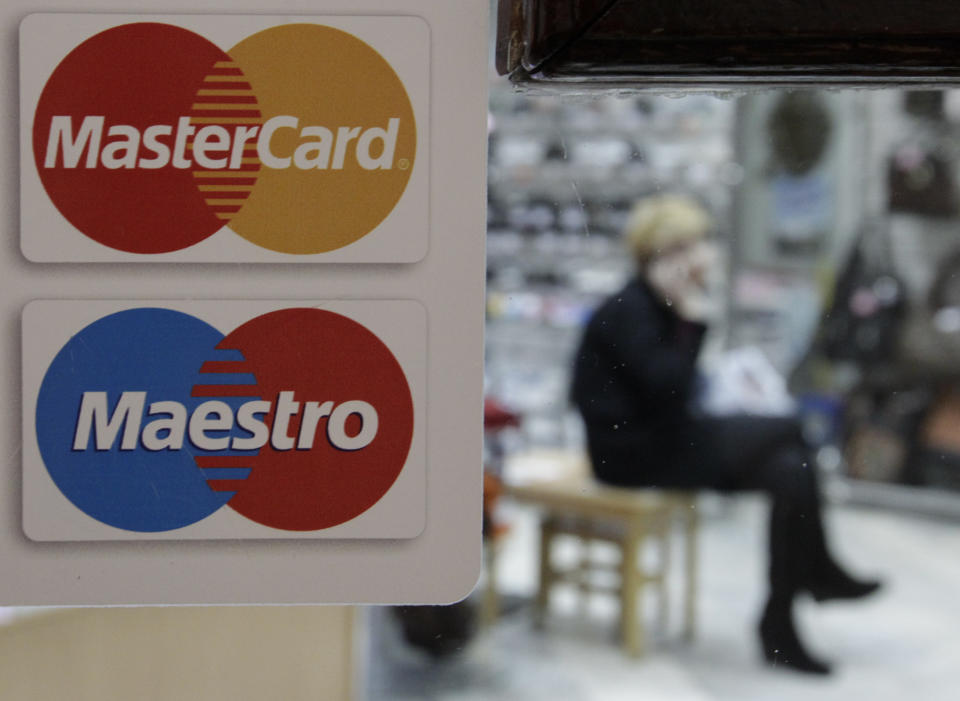 A sign with a logo of MasterCard is seen on the door of a shoe shop. Photo: Eduard Korniyenko/Reuters