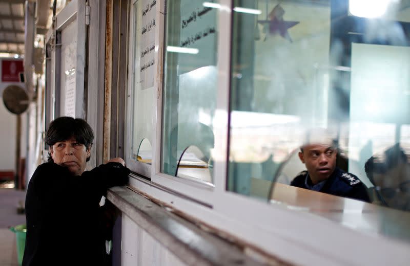 Christian Palestinian woman waits to receive a permit to leave Gaza through Israeli Erez crossing heading to Bethlehem to attend Christmas celebrations, in the northern Gaza Strip