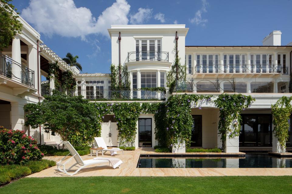 The new house at 726 Hi Mount Road in Palm Beach was designed with several levels to take advantage of the lot's topography. The upper terraces have glass rails with fanciful metalwork ornamentation.