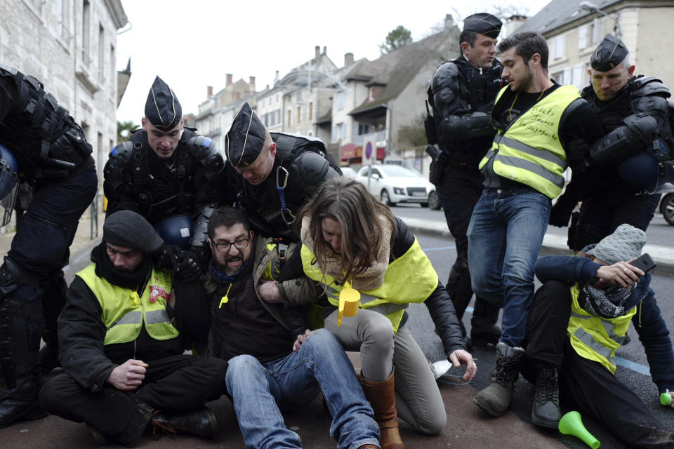 Police remove yellow vest demonstrators staging a sit-down protest in Souillac, southern France, ahead of French President Emmanuel Macron' s visit, Friday, Jan. 18, 2019. Macron is meeting Friday with about 600 mayors and local officials in Souillac, a small town in southwestern France, as part of a national "grand debate".(AP Photo/Fred Scheiber)