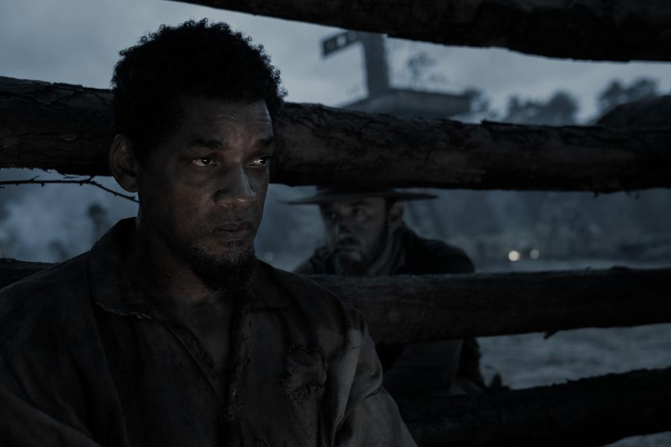 A man sits in the back of a prison car