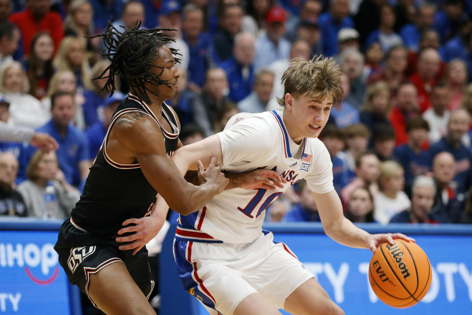 Kansas guard Johnny Furphy, right, attempts to get past Oklahoma State guard Javon Small during the first half of an NCAA college basketball game, Tuesday, Jan. 30, 2024, in Lawrence, Kan. (AP Photo/Colin E. Braley)