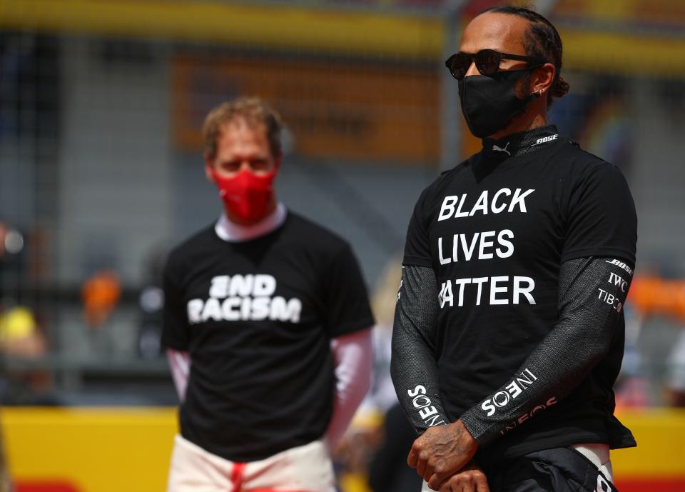 Ferrari's German driver Sebastian Vettel (L) and Mercedes' British driver Lewis Hamilton take part in an anti-racism protest in support of the Black Lives matter movement prior to the Formula One Styrian Grand Prix race on July 12, 2020 in Spielberg, Austria. (Photo by Mark Thompson / various sources / AFP) (Photo by MARK THOMPSON/AFP via Getty Images)
