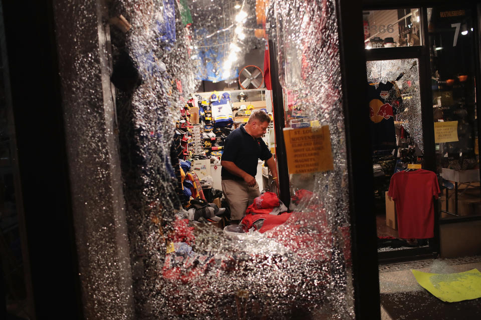 <p>A worker cleans up broken glass from a window smashed during a protest of the acquittal of former St. Louis police officer Jason Stockley on Sept. 16, 2017 in St. Louis, Mo. (Photo: Scott Olson/Getty Images) </p>