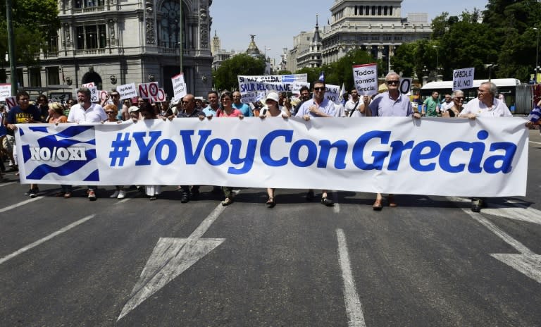 People hold a banner reading "IGoWithGreece" during a demonstration in support of Greece, in Madrid