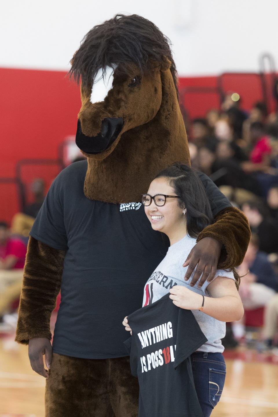 MOT Charter senior Jaana Tabalon poses for a photo with Charter's mascot after graduation.