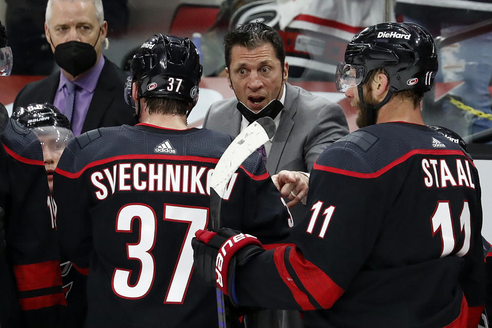Carolina Hurricanes coach Rod Brind'Amour, center, speaks with players during the third period in Game 2 of the team's NHL hockey Stanley Cup second-round playoff series against the Tampa Bay Lightning in Raleigh, N.C., Tuesday, June 1, 2021. (AP Photo/Karl B DeBlaker)