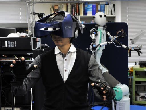 An operator -- wearing a special HMD and a pair of gloves -- controls the "Telesar V" (right) that was developed by Keio University's Graduate School professor Susumu Tachi (not in the picture) at his laboratory in Yokohama, suburban Tokyo. The robot that mimics the movements of its human controller is bringing the Hollywood blockbuster "Avatar" one step closer to reality