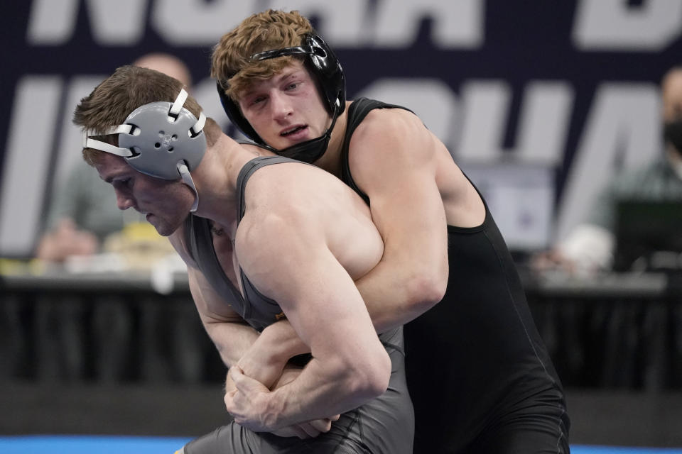 FILE - Stanford's Shane Griffith, right, takes on Pittsburgh's Jake Wentzel during their 165-pound match in the finals of the NCAA wrestling championships in St. Louis, in this Saturday, March 20, 2021, file photo. Shane Griffith recently captured the 165-pound title at the NCAA wrestling championships wearing a black singlet minus the Stanford logo. This was his way -- his entire team’s way -- of making a statement after the school announced in July that wrestling and 10 other sports, most of them that produce athletes for the U.S. Olympic team, would be dropped to save money.(AP Photo/Jeff Roberson, Filr)