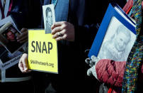 Survivors Network of those Abused by Priests (SNAP) President Tim Lennon from Tucson, AZ, center, and SNAP members Esther Hatfield Miller from Los Angeles, CA, left, and Carol Midboe from Austin, TX, hold pictures as they pose for pictures during interviews with the media in St. Peter's Square at the Vatican during Pope Francis' general audience, Wednesday, Feb. 20, 2019. Organizers of Pope Francis' summit on preventing clergy sex abuse will meet this week with a dozen survivor-activists who have come to Rome to protest the Catholic Church's response to date and demand an end to decades of cover-up by church leaders. (AP Photo/Luigi Navarra)