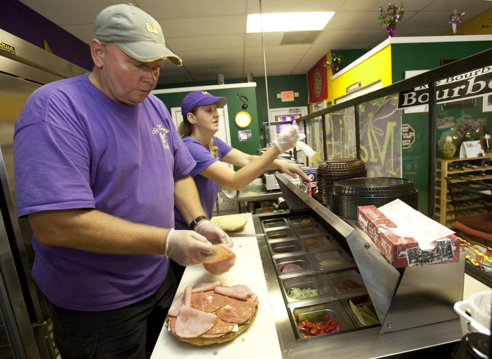 In this Friday, Aug. 3, 2012 photo, Walt and Nicole Mazie prepare food at their restaurant, The Big Easy, in Flagler Beach, Fla. Walt Mazie knows it was risky launching a business during hard times. Business was so dismal at first that on some Friday nights, Mazie says, he and his wife sat outside because there were no customers. They held on, though, and about six months ago, there was a turnaround. Mazie says business has increased about 65 percent over last year, thanks to positive publicity and an improved economy. (AP Photo/John Raoux)