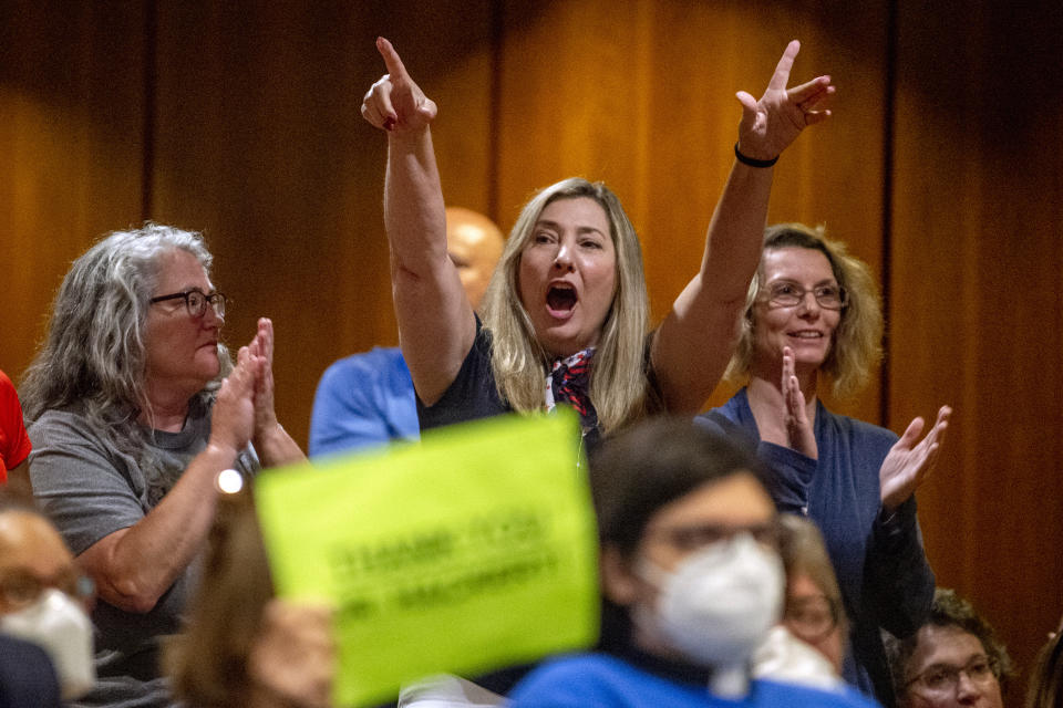 FILE - Amy Facchinello, a Grand Blanc school board member, cheers on a parent who spoke against the county's K-6 school mask mandate during public comment at the Harris Auditorium at a Genesee County Board of Commissioners meeting on Aug. 30, 2021, at the county administration building in downtown Flint, Mich. Nine of the Michigan Republicans, including Facchinello, accused in a fake elector scheme to keep former President Donald Trump in power entered not guilty pleas Thursday, Aug. 10, 2023, in state court. (Jake May/The Flint Journal via AP)