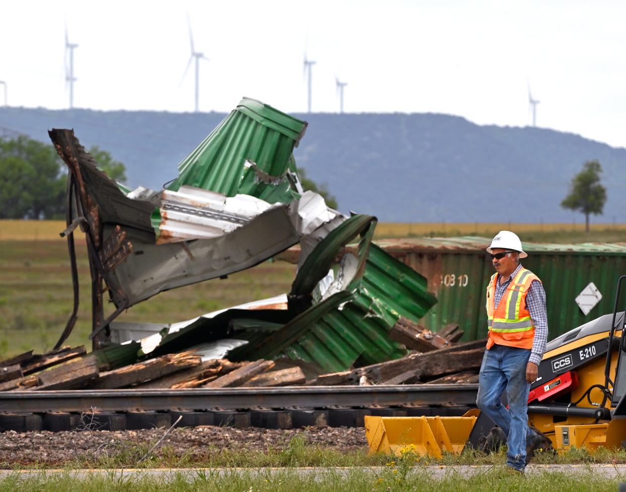 A worker walks past the mangled remains of derailed cars along the railroad between Merkel and Trent Wednesday. No injuries or hazardous materials were reported in the Tuesday night wreck.