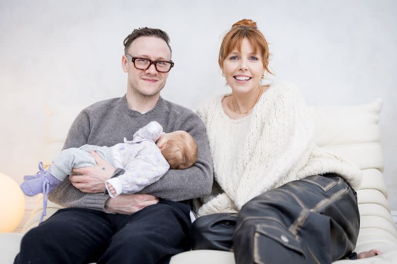 Kevin Clifton holding his newbord daughter alongside Stacey Dooley