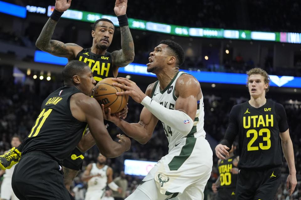 Milwaukee Bucks' Giannis Antetokounmpo tries o drive past Utah Jazz's Kris Dunn during the first half of an NBA basketball game Monday, Jan. 8, 2024, in Milwaukee. (AP Photo/Morry Gash)