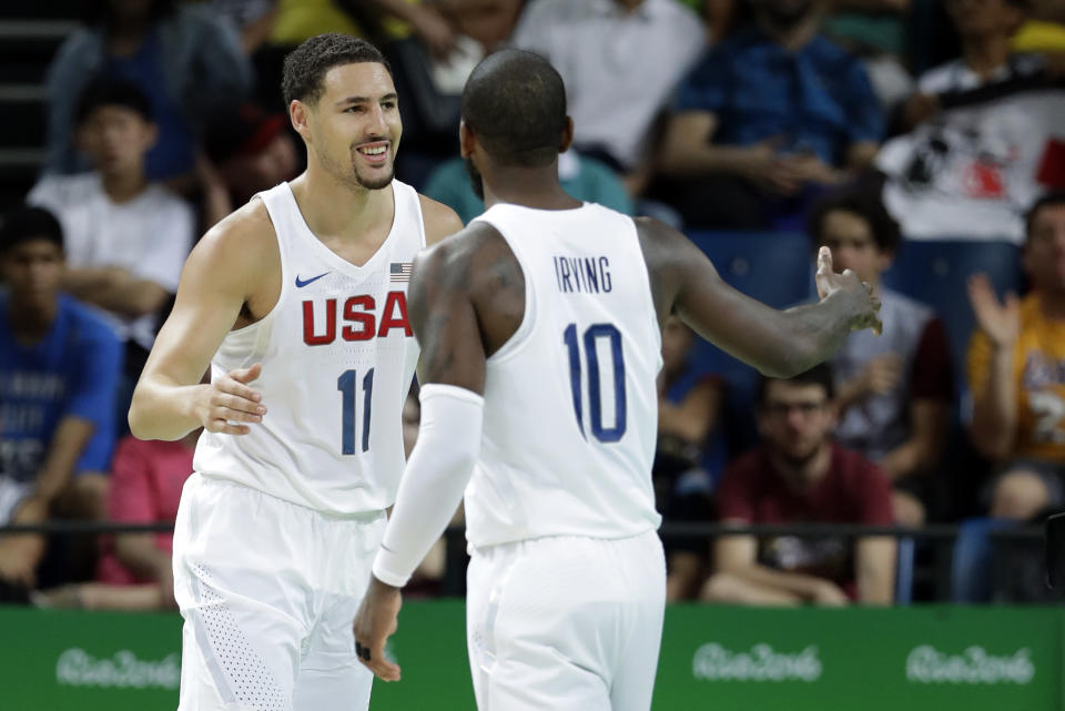 Klay Thompson gets a high-five from Kyrie Irving. (AP)