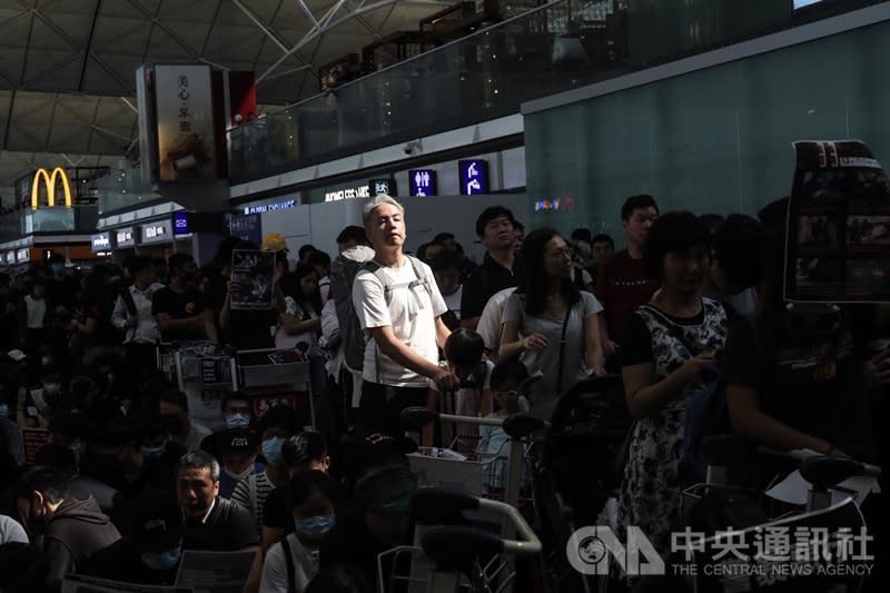 香港「反送中」抗爭11日遭警方空前強勢鎮壓，一名示威女子遭射傷右眼，引發黑衫軍強烈憤慨，12日中午1時號召支持者全面罷工，百萬人塞爆機場，有旅客被擠在抗爭人群中。（中央社）