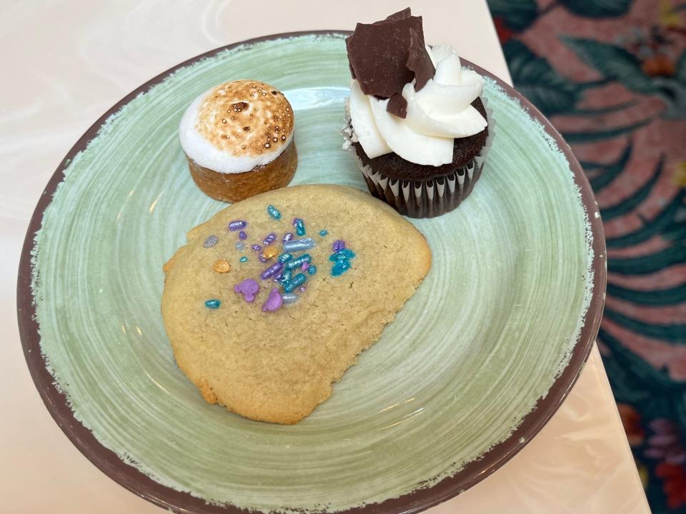 Plate with sugar cookie, marshmallow dessert, and chocolate cupcake.