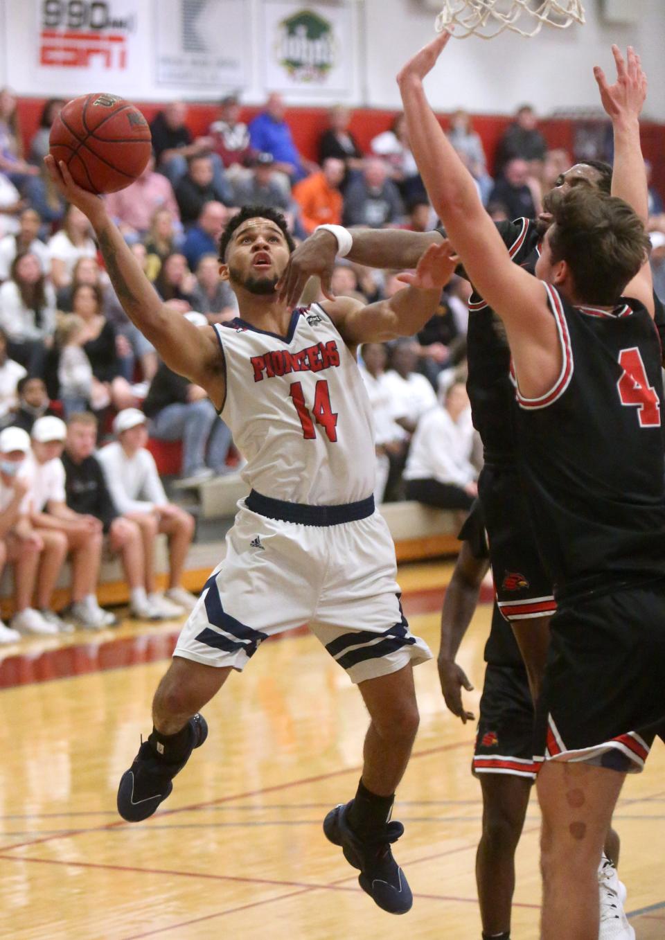 Bryce Butler (14) of Malone goes to the basket while being defended by Tre Massey (4) of Wheeling during their game at Malone on Wednesday.