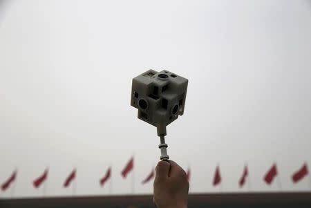 A reporter holds a 360 degree virtual reality camera in front of the Great Hall of the People before the opening session of the Chinese People's Political Consultative Conference (CPPCC), in Beijing, China, March 3, 2016. REUTERS/Kim Kyung-hoon