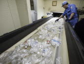 In this June 18, 2019, photo, a plastic recycling company worker makes hand sorting on plastic bottles at Tokyo Petbottle Recycle Co., in Tokyo. Japan has a plastic problem. Single bananas here are sometimes wrapped in plastic. So are individual pieces of vegetables, fruit, pastries, pens and cosmetics. Plastic-wrapped plastic spoons come with every ice cream cup. But as world leaders descend on Osaka for the two-day G20 Summit that starts Friday, June 28, Japan has ambitions to become a world leader in reducing plastic waste. (AP Photo/Koji Sasahara)