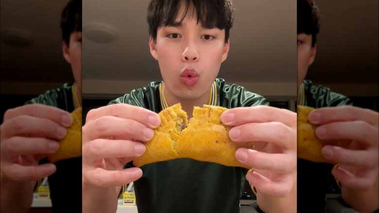 Newt Nguyen holding up empanada