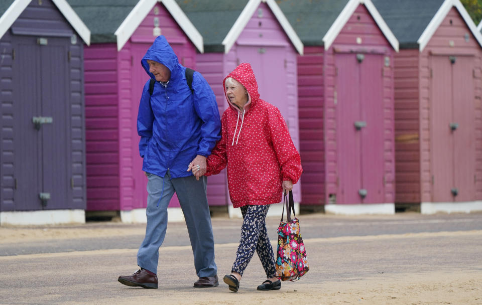 <p>People wearing raincoats make their way past beach huts on Bournemouth beach in Dorset. Picture date: Wednesday June 2, 2021.</p>
