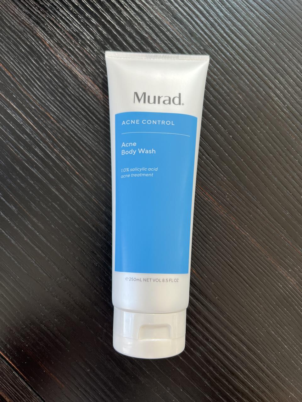 a bottle of the murad acne control acne body wash resting on the floor