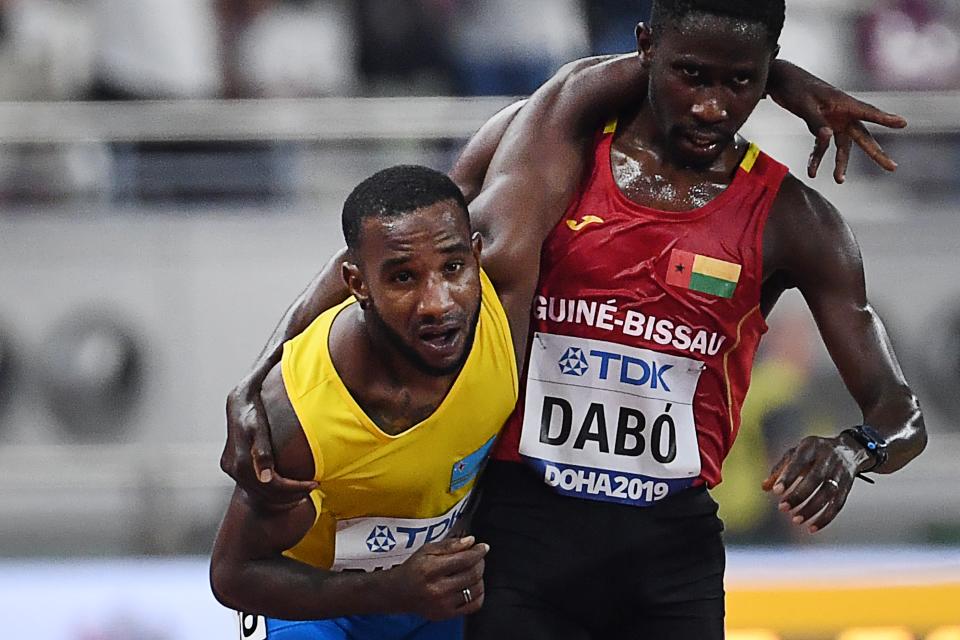 Guinea-Bissau's Braima Suncar Dabo, right, helps Aruba's Jonathan Busby to the finish line during the men's 5000 meter heats at the 2019 IAAF World Athletics Championships on Friday. (Getty Images)