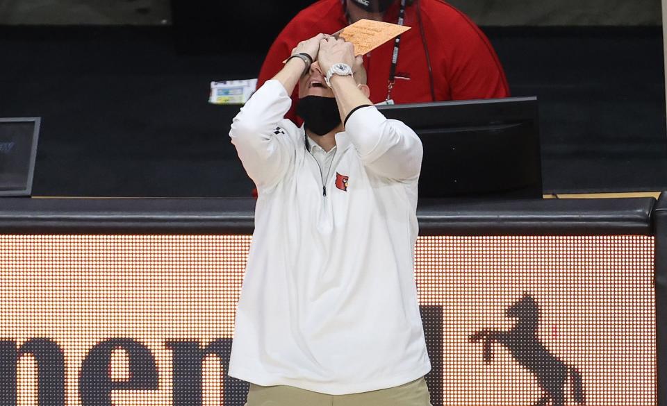 Chris Mack throws his head back and covers his face with his hands in reaction to a play that went against his team.