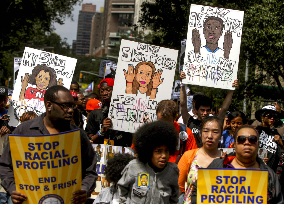 File-This photo from Sunday, June 17, 2012, shows protestors with signs during a silent march to end "stop-and-frisk" program in New York. During the Bloomberg administration, civil rights groups went to court to end the NYPD's use of a tactic known as "stop and frisk," which involved detaining, questioning and sometimes searching people deemed suspicious by officers. (AP Photo/Seth Wenig, File)