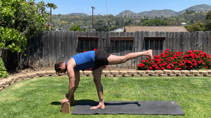 Man on a yoga mat outside in his backyard practicing yoga for tall peoples