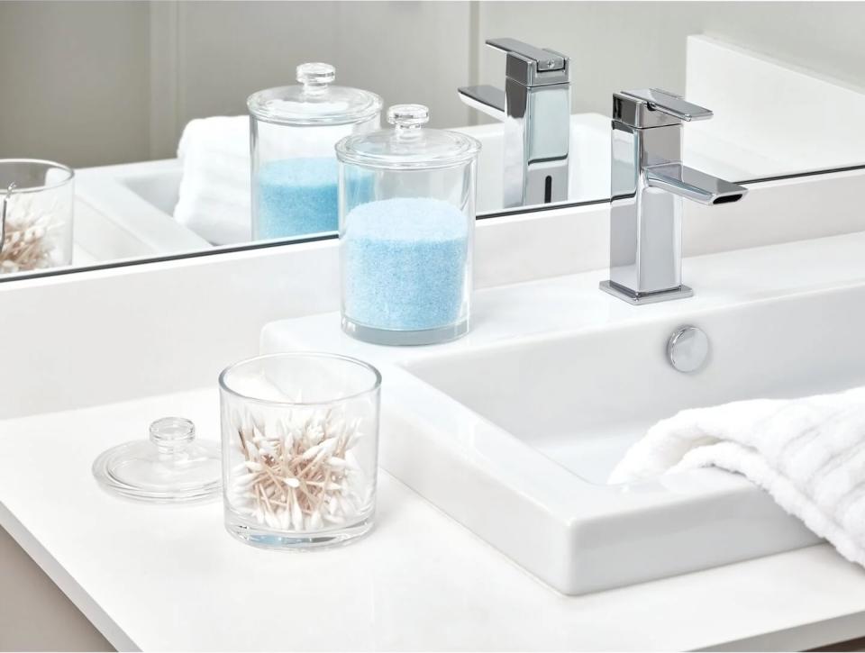 small clear jars with lids next to a sink