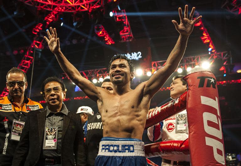 Manny Pacquiao celebrates victory against American Chris Algieri after their world welterweight championship bout at the Cotai Arena in Macau on November 23, 2014