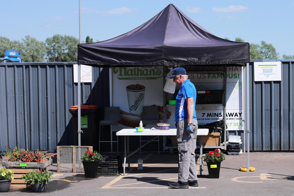 An elderly member of the public wearing gloves to protect against the ongoing coronavirus pandemic looks at a plant sale from Test Valley Plants outside Eastleigh FC�s Silverlake Stadium in Eastleigh, England