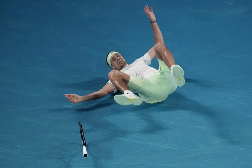 Alexander Zverev of Germany falls during his quarterfinal match against Carlos Alcaraz of Spain at the Australian Open tennis championships at Melbourne Park, Melbourne, Australia, early Thursday, Jan. 25, 2024. (AP Photo/Louise Delmotte)