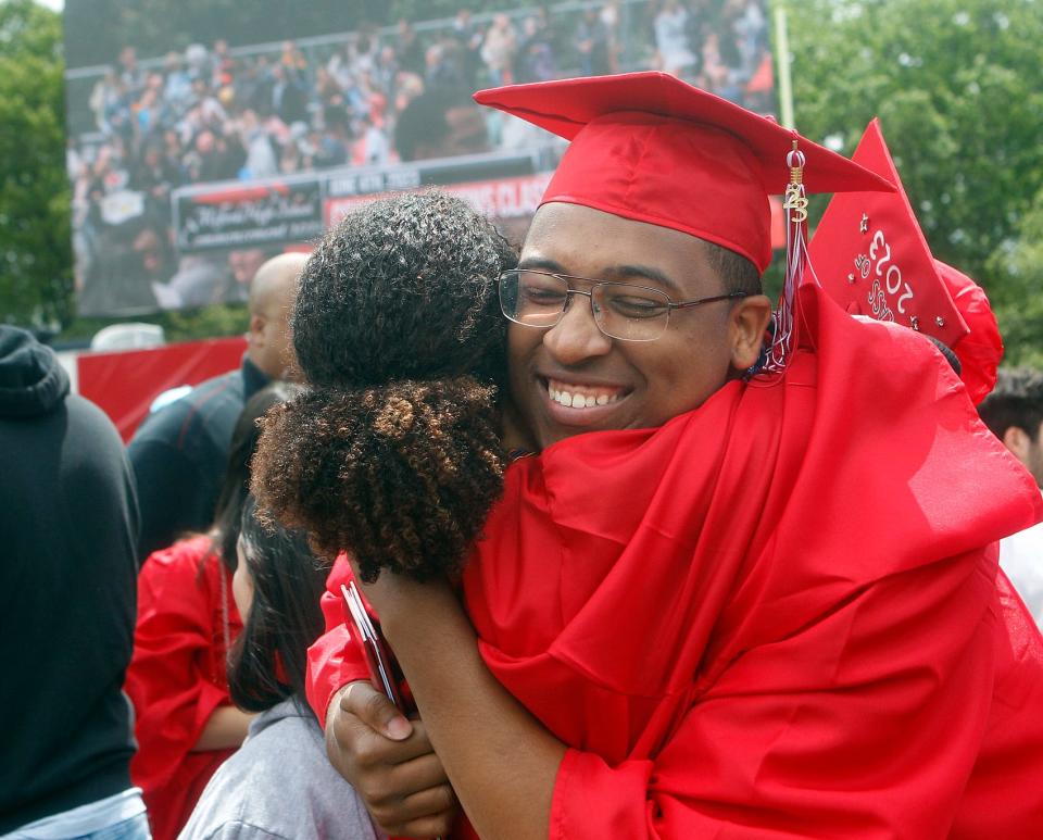 Jason Lee Darling, right, gets a hug from classmate Jordan Anastasia Payton as their graduation ceremony concludes on the football field at Milford High School, June 4, 2023.