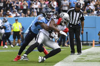 Las Vegas Raiders wide receiver Davante Adams (17) catches a touchdown pass as Tennessee Titans safety Kevin Byard (31) hangs on in the first half of an NFL football game Sunday, Sept. 25, 2022, in Nashville, Tenn. (AP Photo/John Amis)