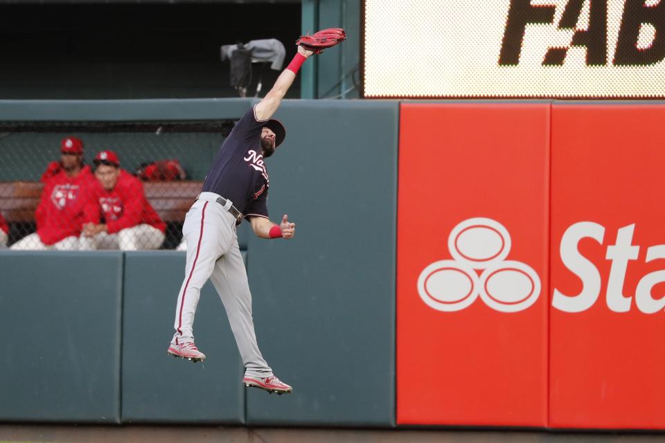 Washington Nationals' Adam Eaton leaps to catch a ball hit by St. Louis Cardinals' Tommy Edman during the eighth inning of Game 2 of the baseball National League Championship Series Saturday, Oct. 12, 2019, in St. Louis. (AP Photo/Jeff Roberson)