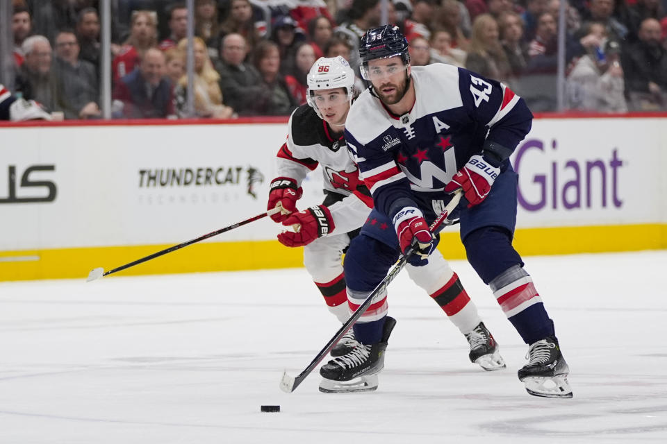 Washington Capitals right wing Tom Wilson (43) skates in front of New Jersey Devils center Jack Hughes (86) in the first period of an NHL hockey game Tuesday, Feb. 20, 2024, in Washington. (AP Photo/Alex Brandon)