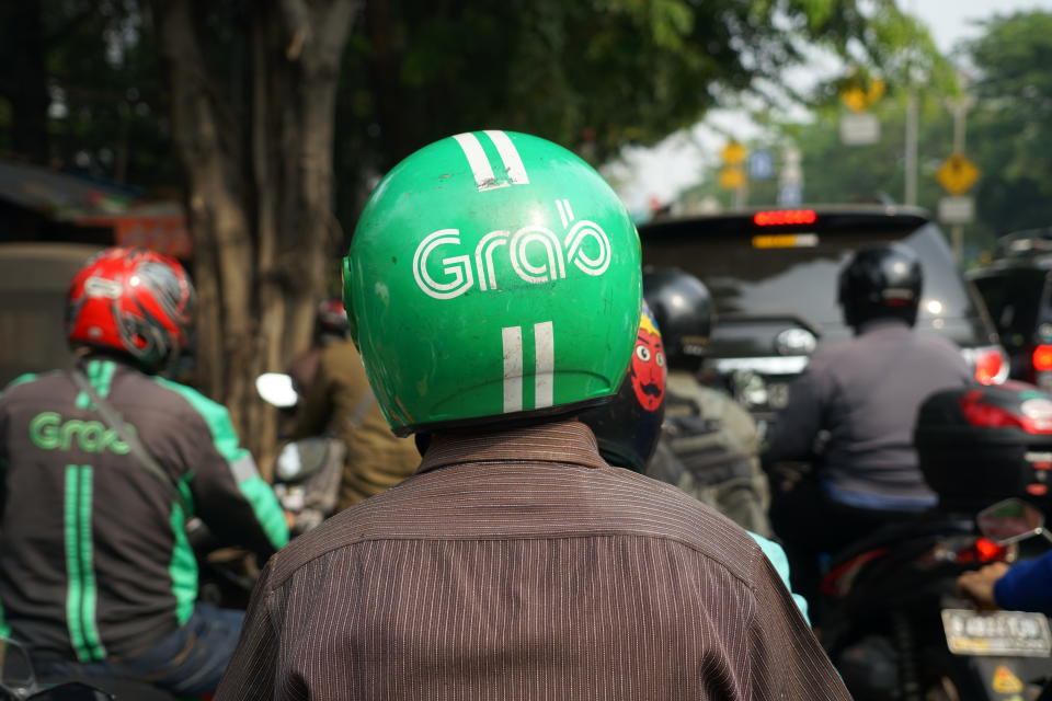 Jakarta, Indonesia - May 2 2018: Bike passengers wearing Helmet with Grab Logo. Grab is a technology company that offers wide range of ride-hailing and logistics services through its app in Southeast A