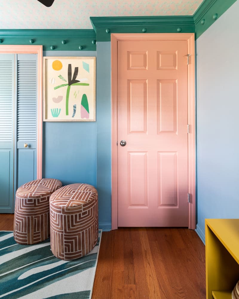 Coral painted door in colorful bedroom.