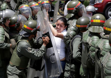 Gaby Arellano, deputy of the Venezuelan coalition of opposition parties, clashes with national guards during a rally against Venezuela's President Nicolas Maduro's government in Caracas. REUTERS/Marco Bello